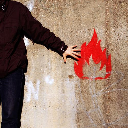 Flammable Feuermelder brennen Mann Wand Mauer Symbole & Metaphern anzünden Hand rot Junger Mann zündeln Brand gefährlich Graffiti Wandmalereien Warnhinweis