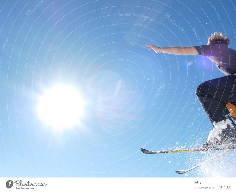 flying into the sun Licht springen Sport Spielen Sonne Freude Himmel Schnee blau Skifahren