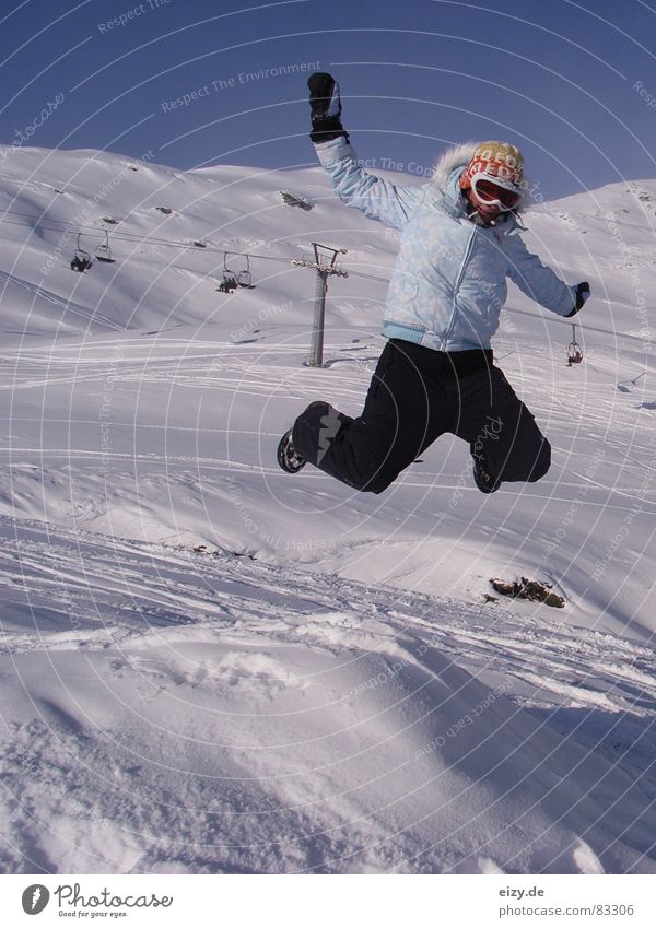 jump Frau Stil Österreich Freude Wintersport Berge u. Gebirge Schnee Skipiste genießen springen Schneebrille Witz Körperhaltung Skilift Sesselbahn hoch