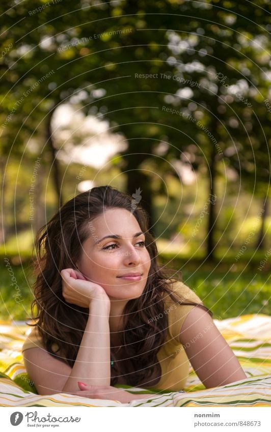 Porträt einer schönen jungen Frau, die auf dem Rasen im Park liegt. Lifestyle Freude Erholung Erwachsene Jugendliche 18-30 Jahre Natur Sommer Gras Wiese Lächeln