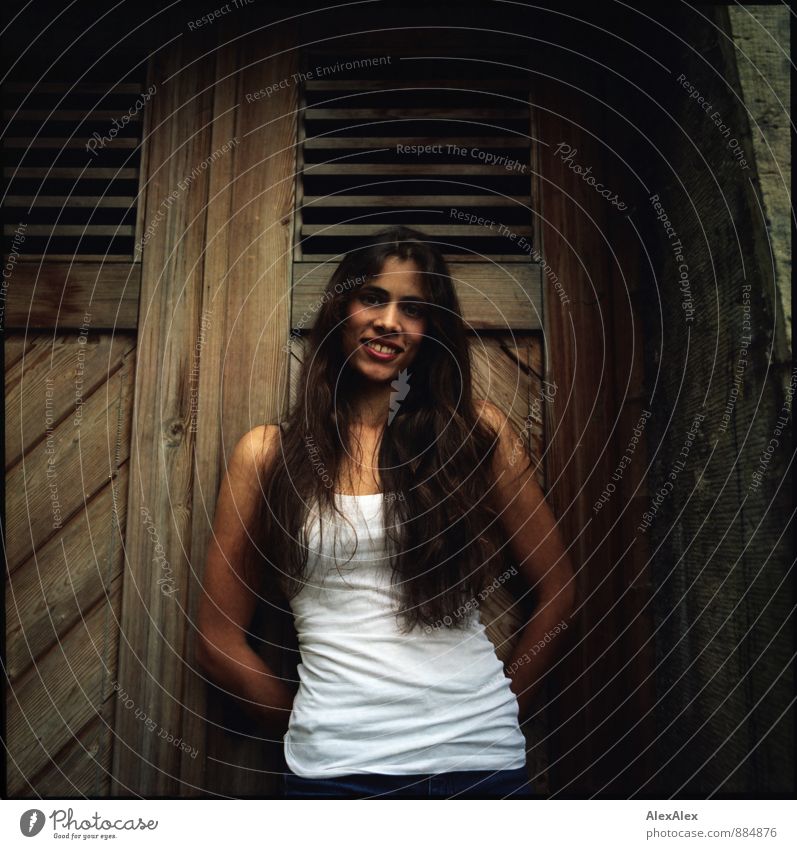 analoges Portrait einer jungen, langhaarigen, schönen Frau vor einer Holztür Junge Frau Jugendliche 18-30 Jahre Erwachsene Mauer Unterhemd brünett Lächeln