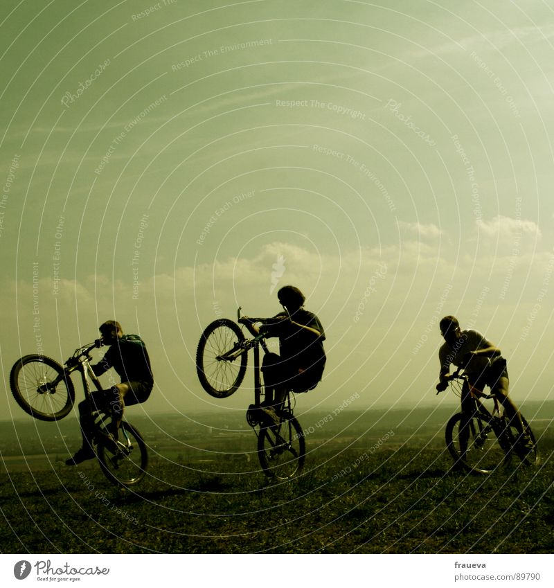 the world is a playground Fahrradfahren Mann maskulin Motorradfahrer toben Wolken grün Spielen Außenaufnahme Fröhlichkeit Ausgelassenheit Freude Menschengruppe
