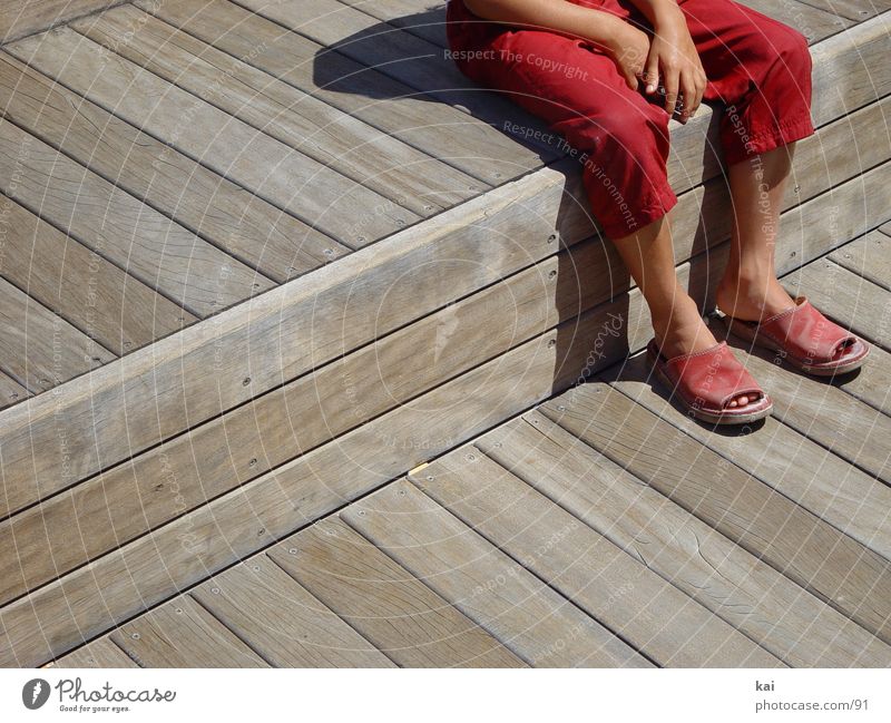 Pause Mädchen Hose rot Hand Fototechnik sitzen Fuß Sandale Bildausschnitt Außenaufnahme warten