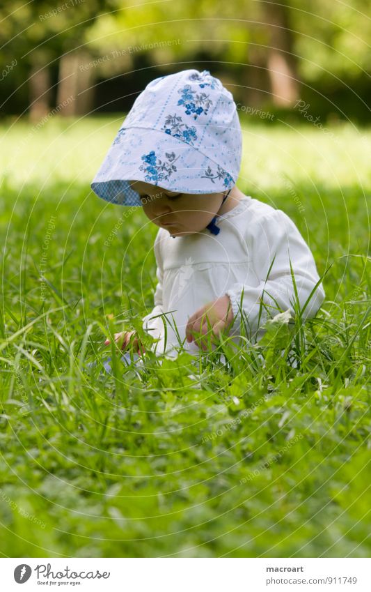 Neugier Kind Baby Kleinkind Mädchen Mütze Gras Wiese sitzen entdecken Blick feminin grün Sommer Frühling Außenaufnahme Natur