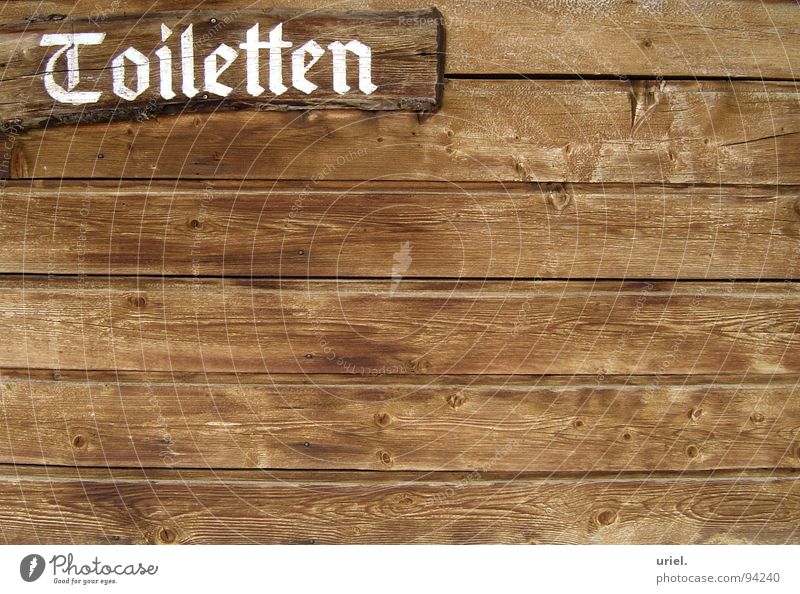 Jeder muss mal... Holz Wand braun Pissoir Skihütte Südtirol Hinweisschild Bad Gastronomie Lamelle Holzbrett Schriftzeichen Toilette Wegweiser Hütte