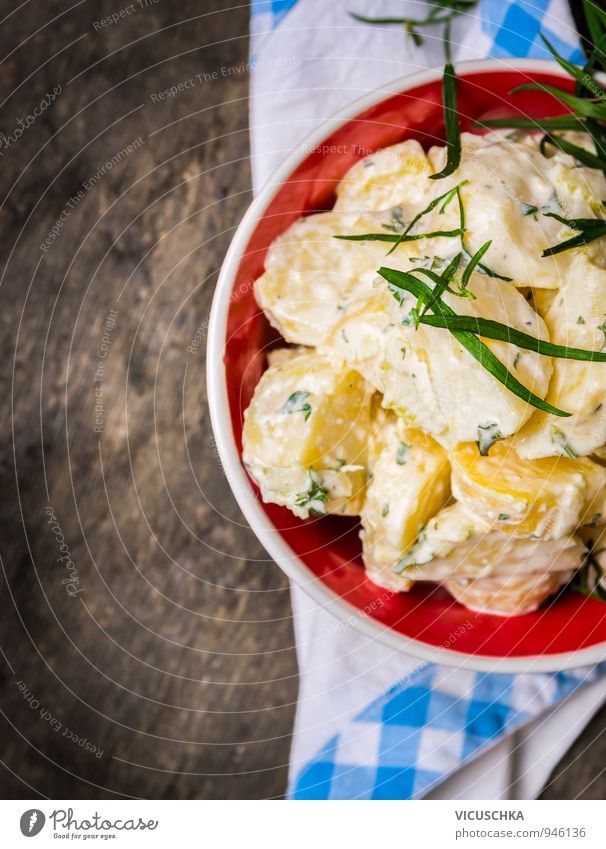 Kartoffelsalat mit Estragon in rote Schüssel. Milcherzeugnisse Gemüse Salat Salatbeilage Kräuter & Gewürze Ernährung Mittagessen Abendessen Büffet Brunch