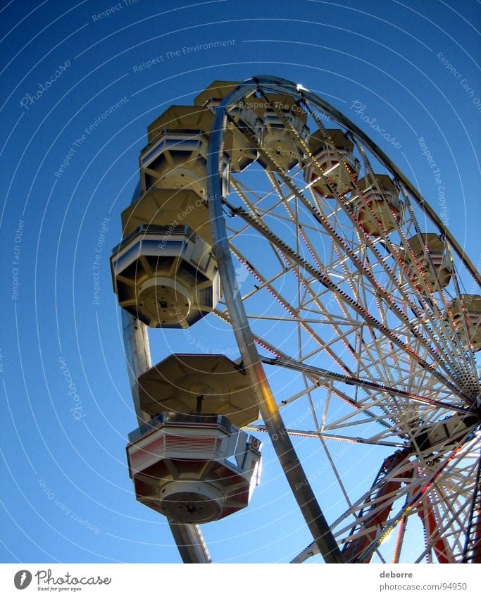Der Blick hinauf zu einem Riesenrad mit blauem Himmel dahinter. gelb groß Jahrmarkt Karussell rund Dinge Freude hoch kreisen