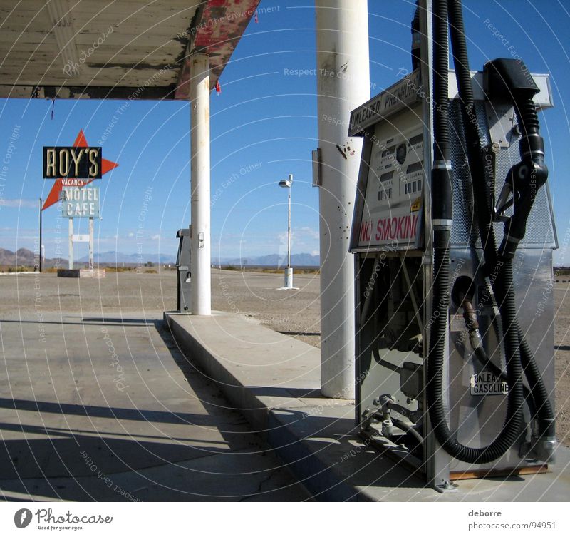 Retroamerikanische Tankstelle an der Route 66 mit dem Schild "Roy's Motel" im Hintergrund. Benzin Rohstoffe & Kraftstoffe tanken Amerika Diesel Erdöl grau