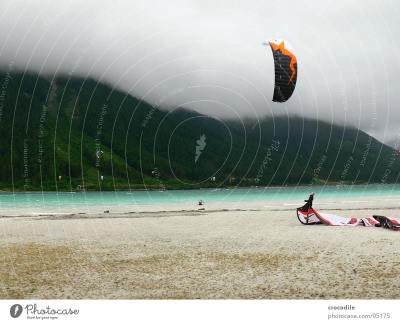 kitesurfing in austria Kiter Surfer See Achensee Bundesland Tirol kalt Wind Wolken Leidenschaft dunkel Strand Schnur Wald Sport gefährlich Mann Extremsport