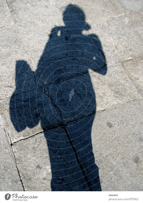 Schatten von Frau mit Tasche auf Stein Ferien & Urlaub & Reisen Sommer Sonne Erwachsene Straße grau Portugal Mittagssonne Reisefotografie Kopfsteinpflaster