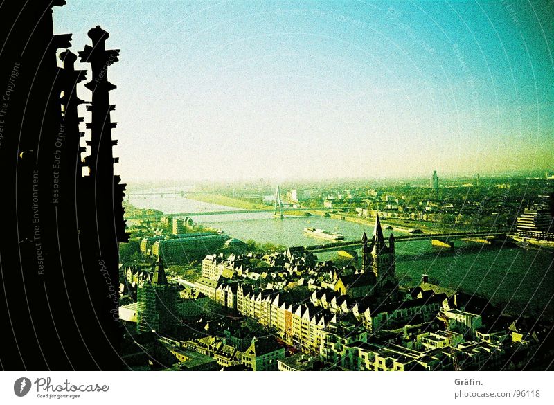 Blick hinab Köln Kölner Dom Aussicht schwarz Säulenkapitell Ferne Horizont Gebäude Denkmal filigran grün Bauherr Dach Häuserzeile Cross Processing Lomografie