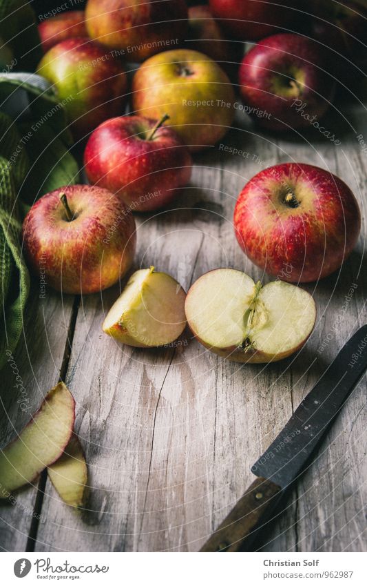 Natürliche Bio-Äpfel der Sorte Elstar auf Holzuntergrund mit angeschnittenen Apfel im Vordergrund Lebensmittel Frucht Apfelschale Bioprodukte Gesunde Ernährung