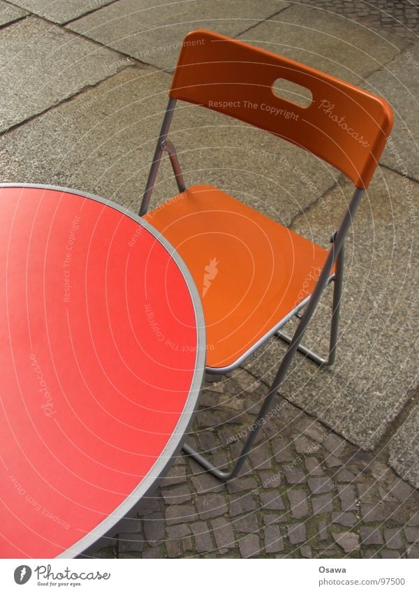 Tisch und Stuhl Café Straßencafé rot Kopfsteinpflaster Bürgersteig Möbel Campingstuhl orange Pflastersteine