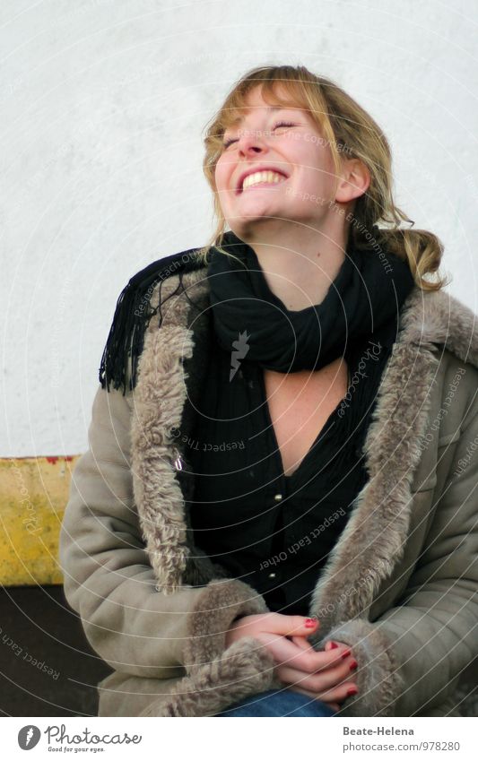 glückliche junge Frau zeigt eine ansteckende Freude Junge Frau Jugendliche Haare & Frisuren Gesicht 18-30 Jahre Erwachsene Mauer Wand Pullover Jacke Fell Schal