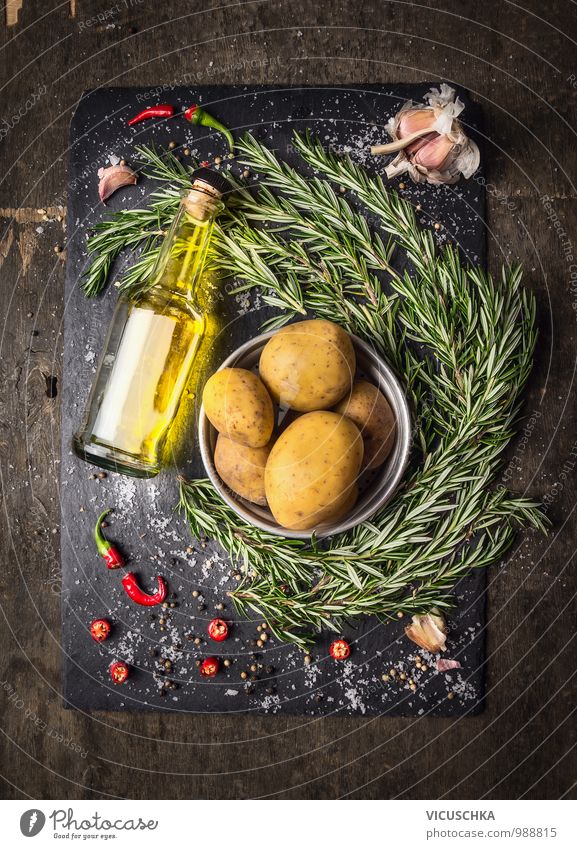 Kartoffeln mit Rosmarin , Gewürze und eine Flasche Öl. Lebensmittel Gemüse Kräuter & Gewürze Ernährung Mittagessen Bioprodukte Vegetarische Ernährung Diät