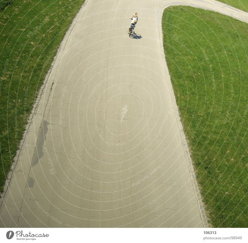 HOCKENHEIM FÜR ARME Frau Fahrrad Fahrradfahren unterwegs Fahrradweg Fahrradtour Straße Kurve Rasen Grünfläche einzeln Vogelperspektive Rückansicht Mobilität