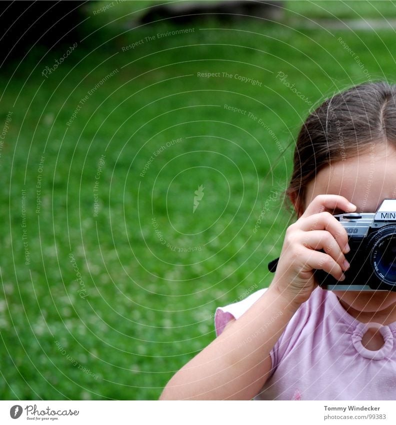 Photogen(e) Mädchen Kind talentiert Fotografie Fotografieren Momentaufnahme Hand Finger Wiese Fotokamera Zopf festhalten filmen analog Körperhaltung Bildung